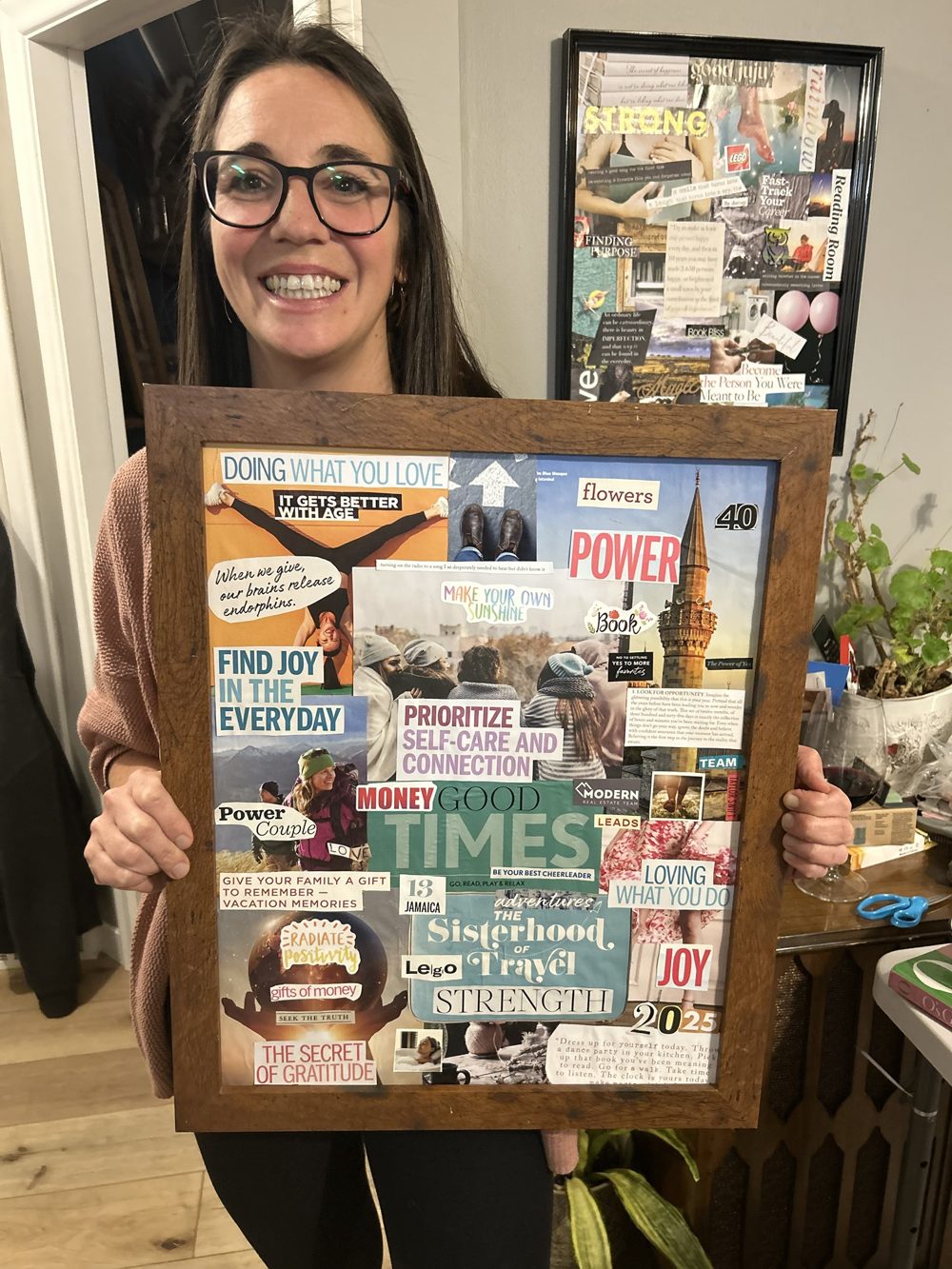 Lindsay smiling and holding up her framed vision board